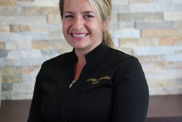 Smiling woman in black uniform, stone wall background